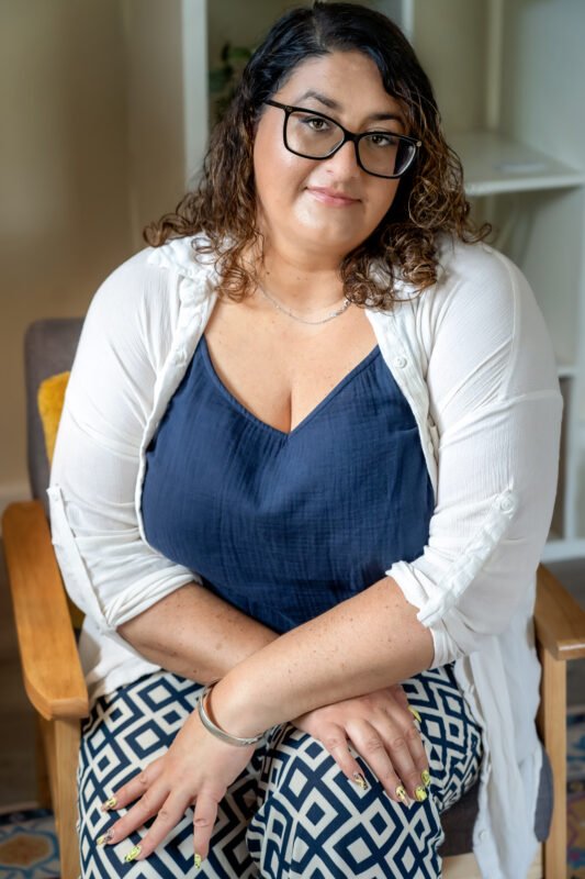 Louiza Leneghan, psychotherapeutic counsellor, seated in the Empowering Minds therapy room